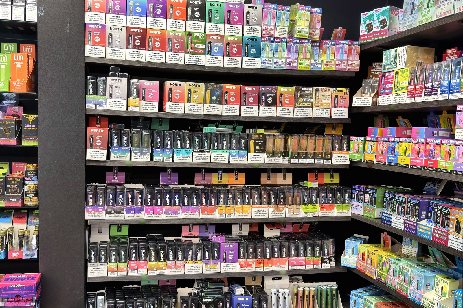 Aisle of disposable vapes stretching to the back of the store