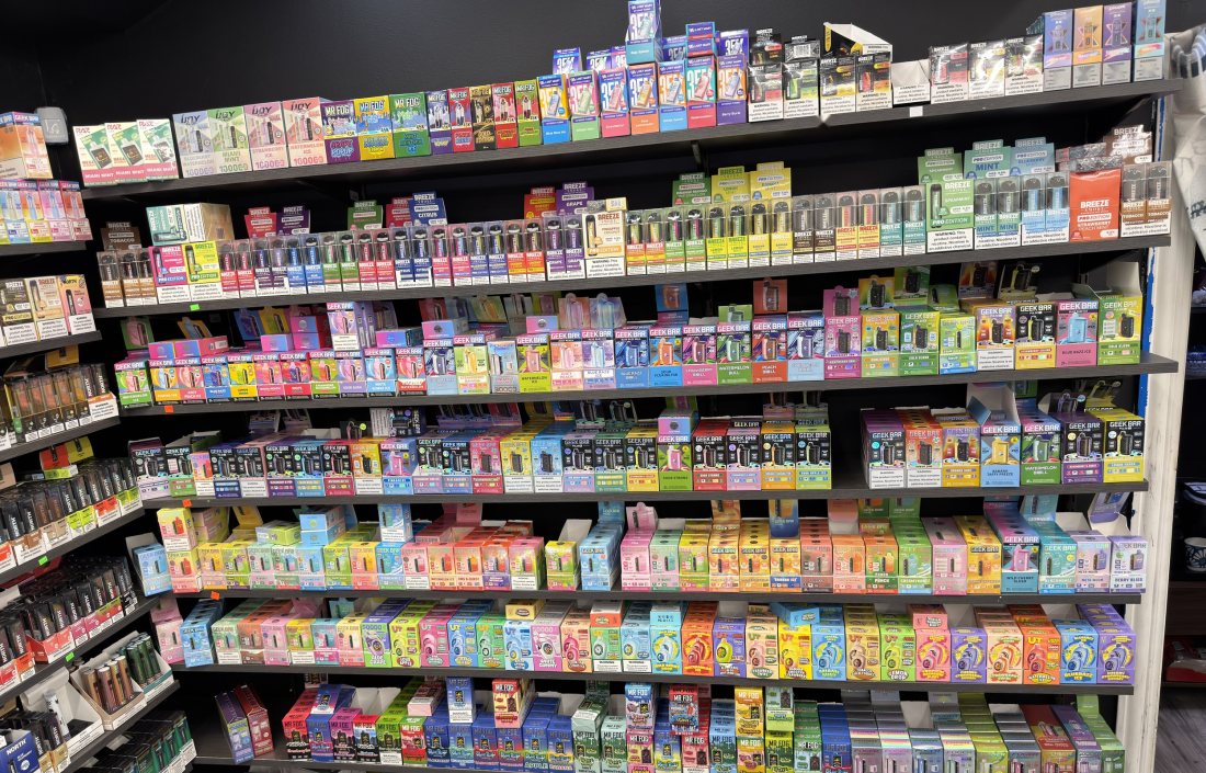 Rows of disposable vapes filling a full wall of shelving