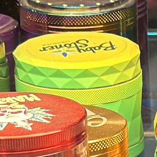 Baby Stoner Neon Yellow and Lime 4-Piece Grinder on the shelf at Glen Smoke Shop