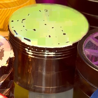 Black 4-Piece Grinder with Neon Circuit Lid on the shelf at Glen Smoke Shop