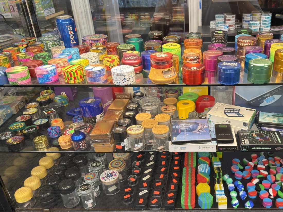 Two shelves of metal grinders in anodised and printed finishes