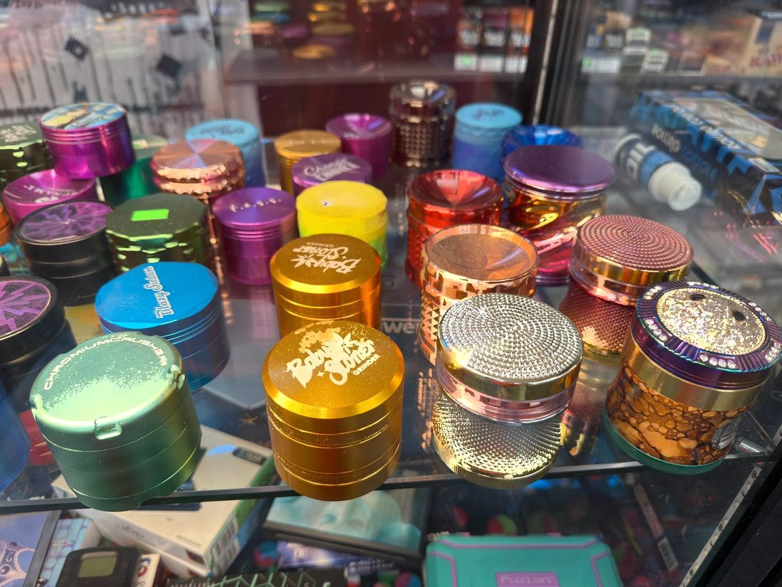 Anodized aluminum grinders in a range of colors on a glass shelf