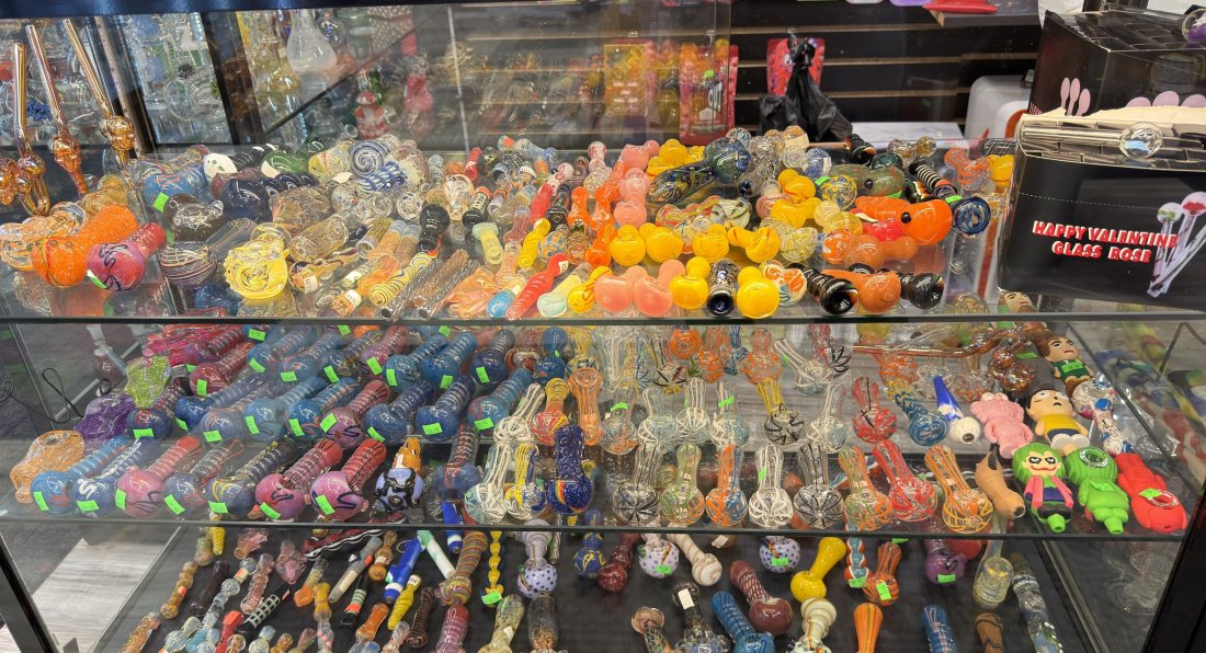 A counter case of hand-blown glass hand pipes in many colours