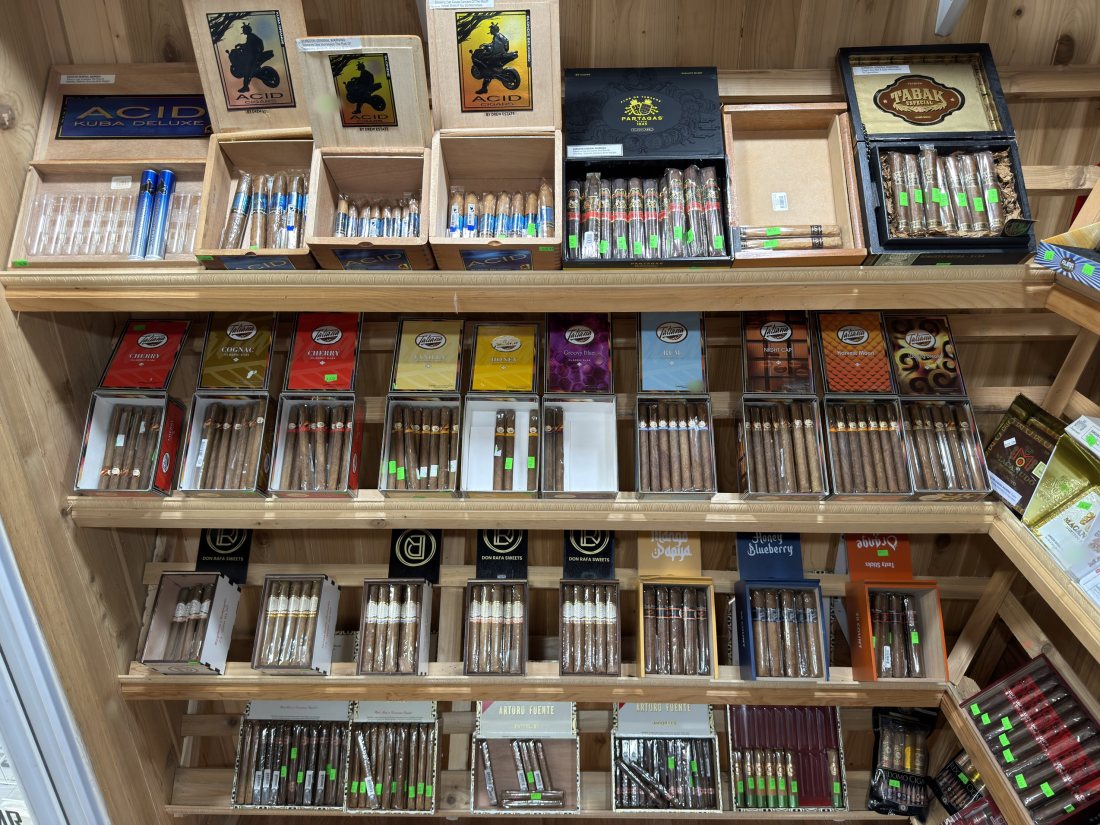 Cedar shelves of the walk-in humidor stacked with cigar boxes and singles
