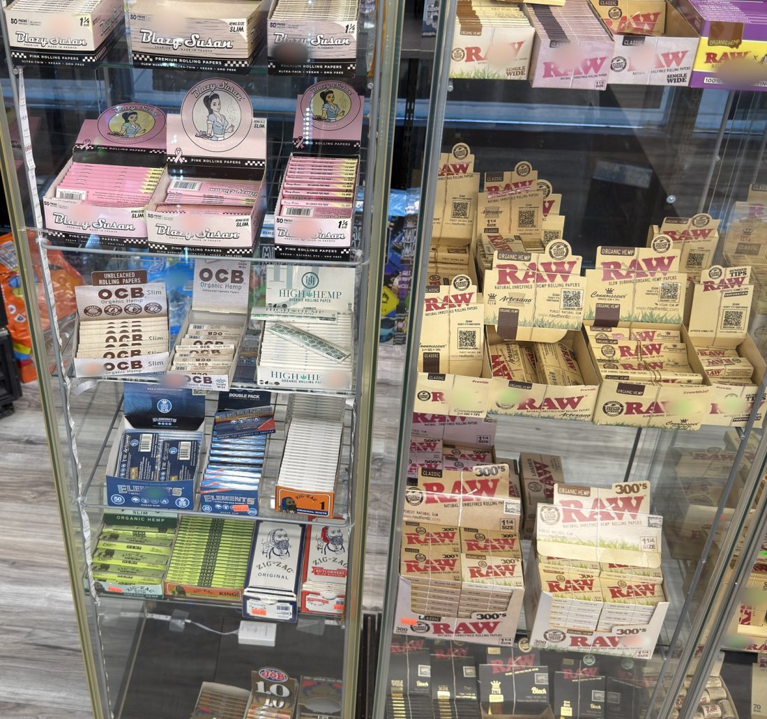 Blazy Susan, OCB and RAW rolling papers through a lit display case at Glen Smoke Shop