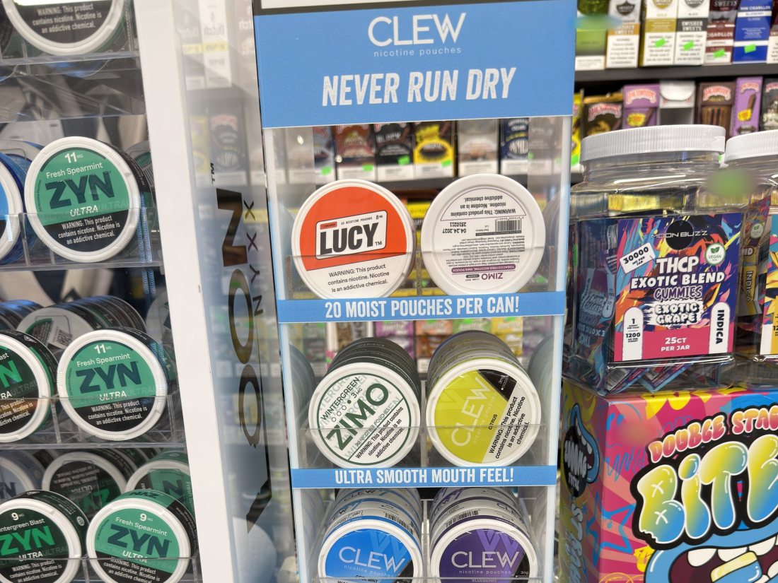 ZYN, CLEW, Lucy and Zimo nicotine pouch tins on a countertop rack