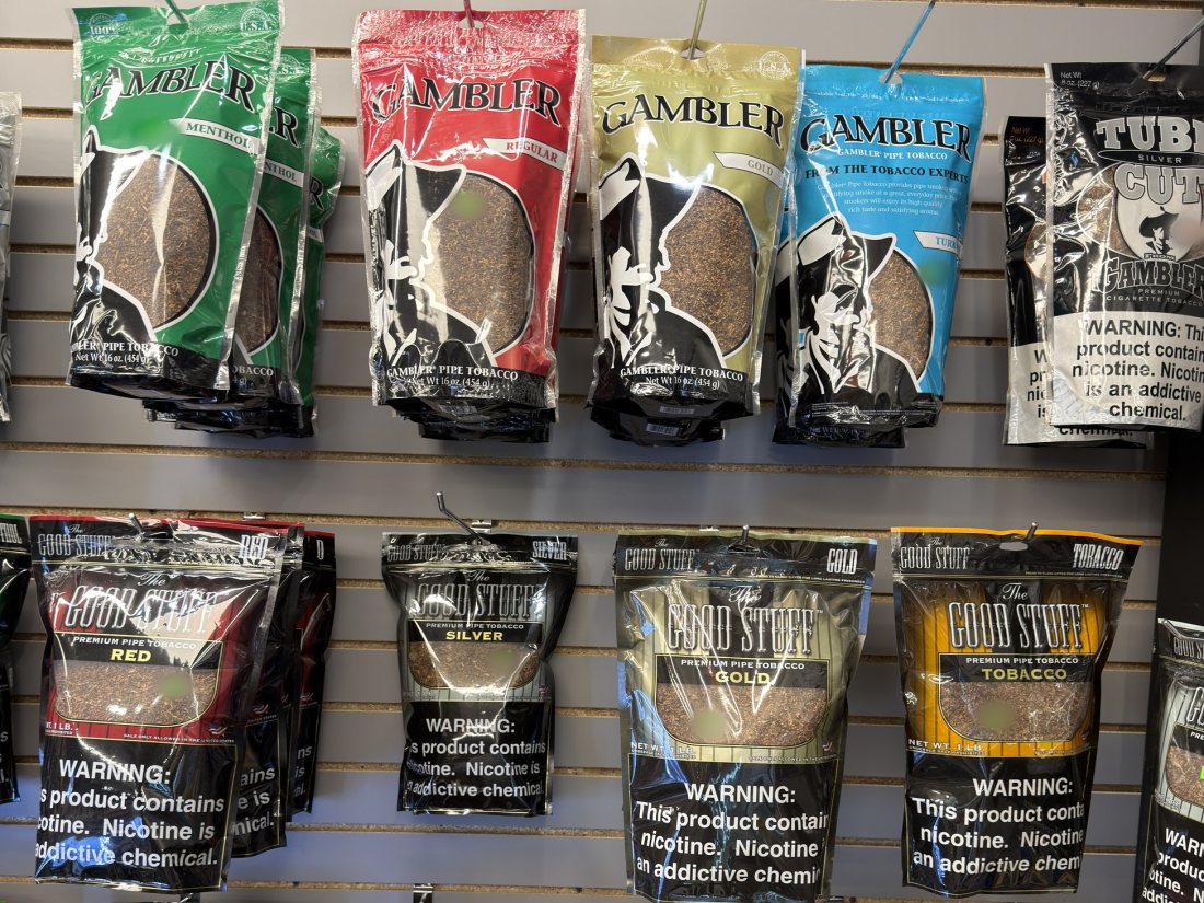 Bagged rolling tobacco and shisha on the slatwall behind the counter