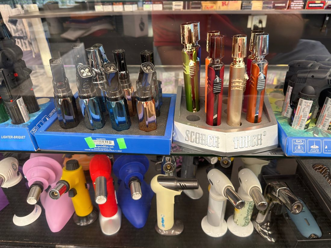 Display trays of jet-flame torch lighters in the glass countertop case