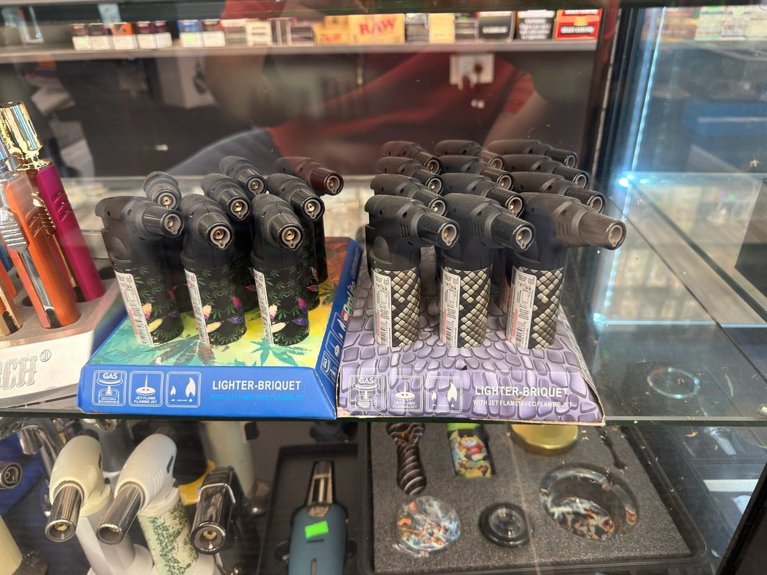 Rows of boxed single and multi-jet butane torch lighters in the display case