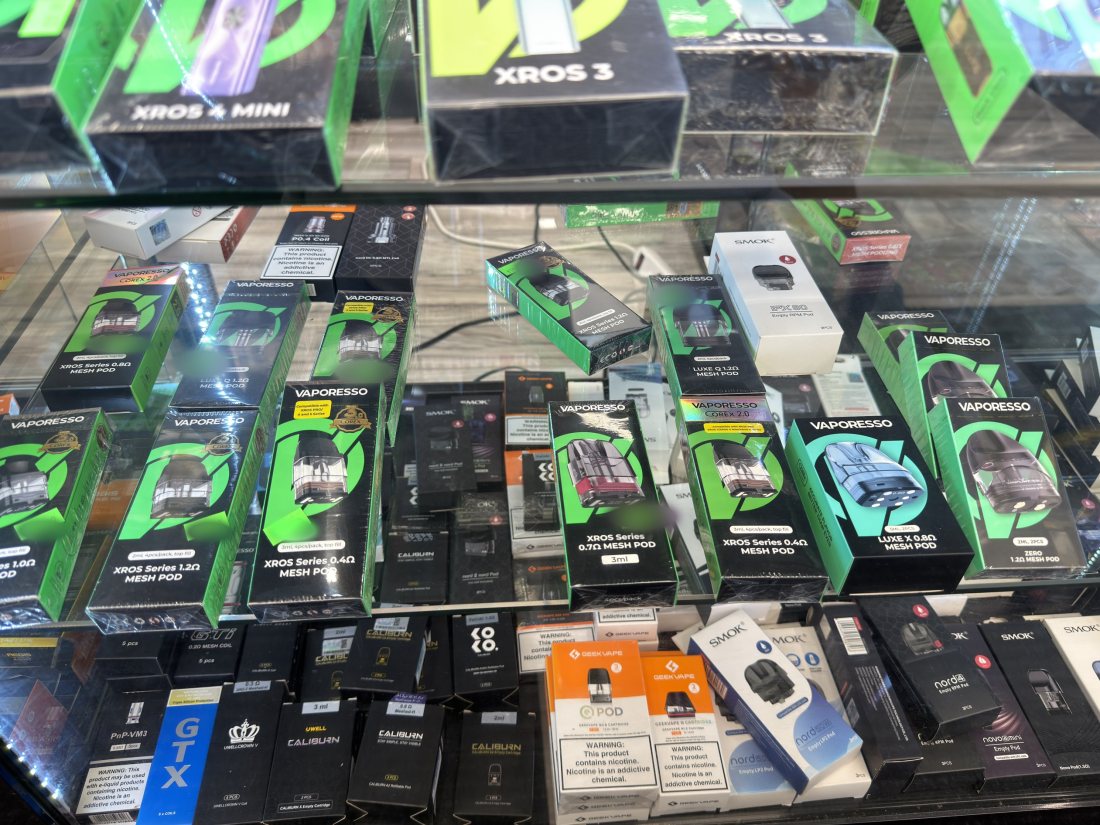 Vaporesso XROS and Uwell Caliburn pod kits boxed in a display case
