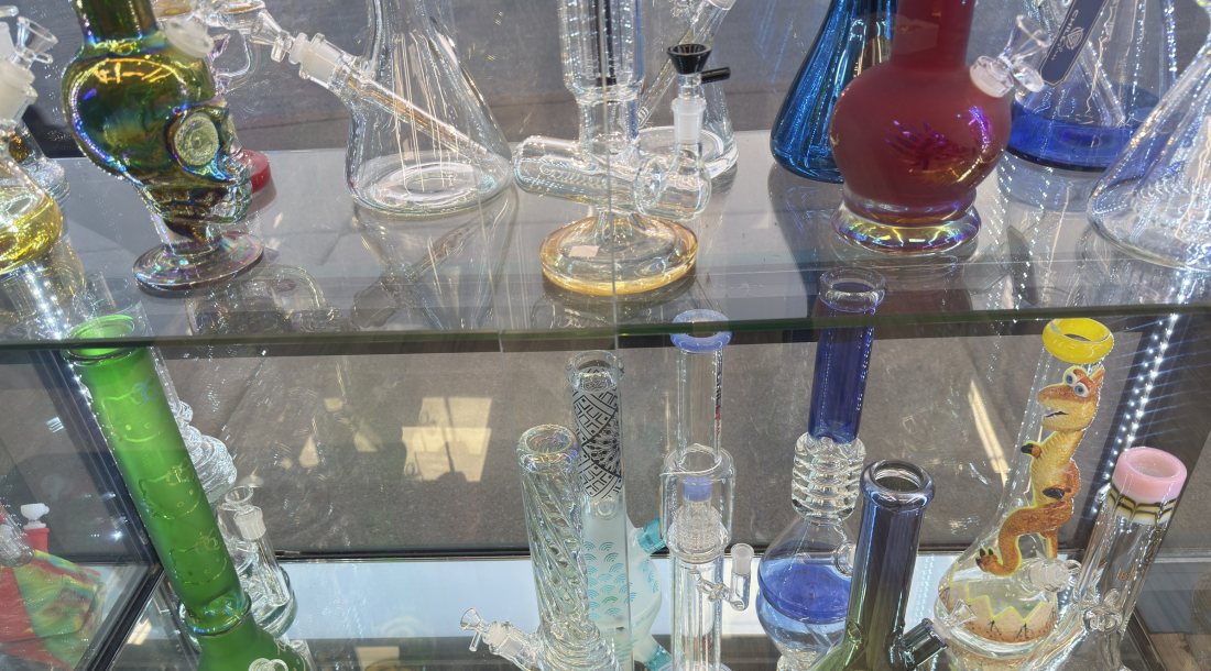Tall straight-tube water pipes and recyclers in a glass case